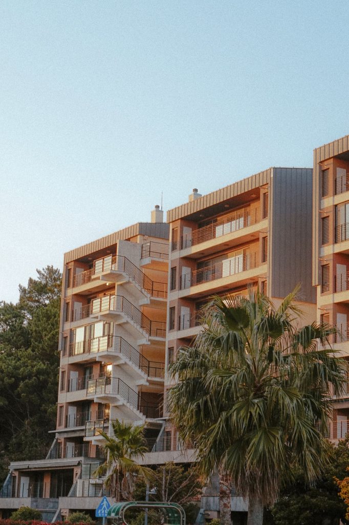 Apartment building with palm trees at sunset